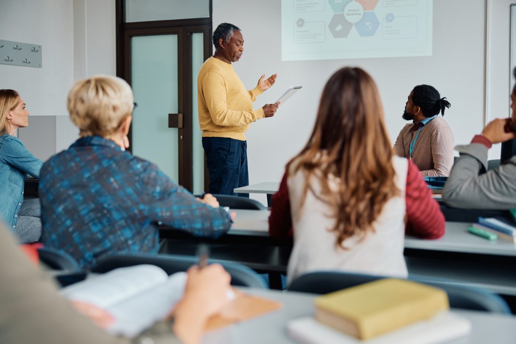 An adult education classroom filled with people while an instructor gives a presentation